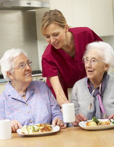 Carer serving meals to clients